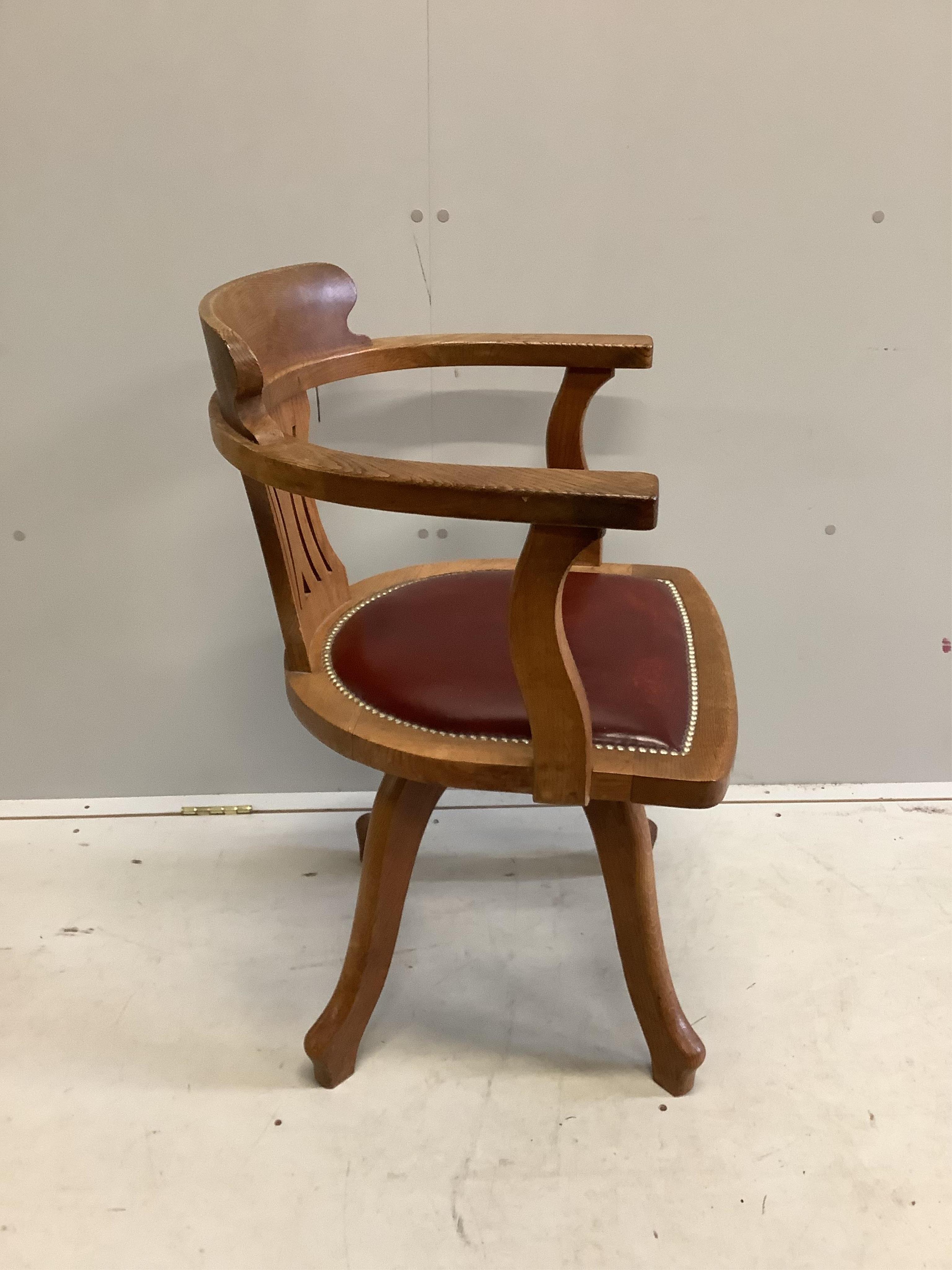 An early 20th century oak swivel desk chair with leather seat, width 61cm, depth 52cm, height 87cm. Condition - fair to good